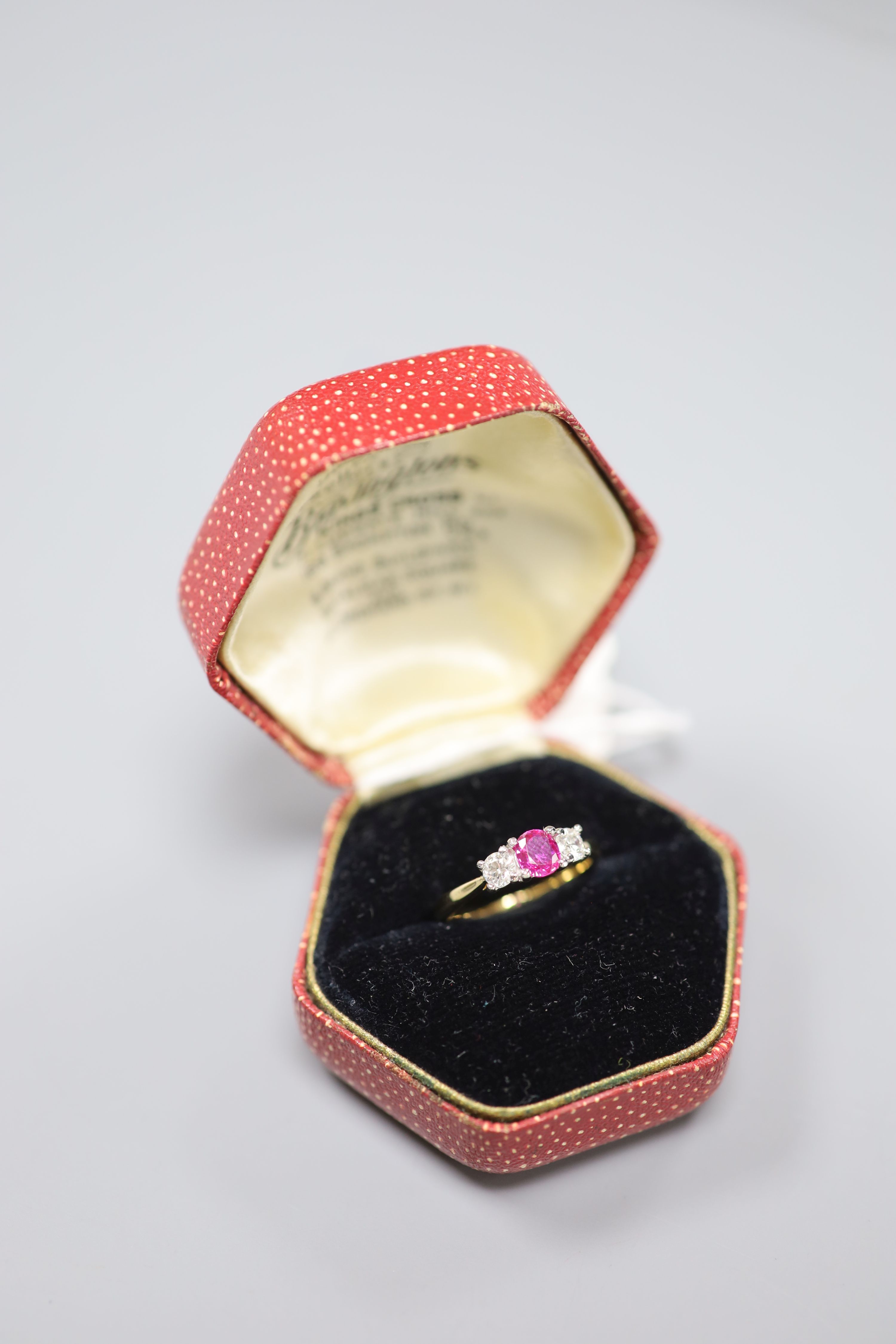 A modern 18ct gold and platinum, ruby and diamond set three stone ring, size M, gross 3.3 grams.